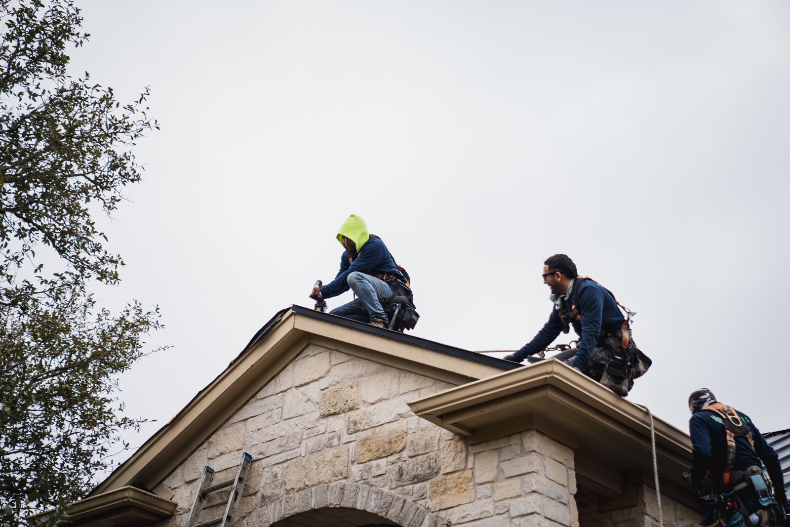 Two Hermes crew members working together at the roof ridge