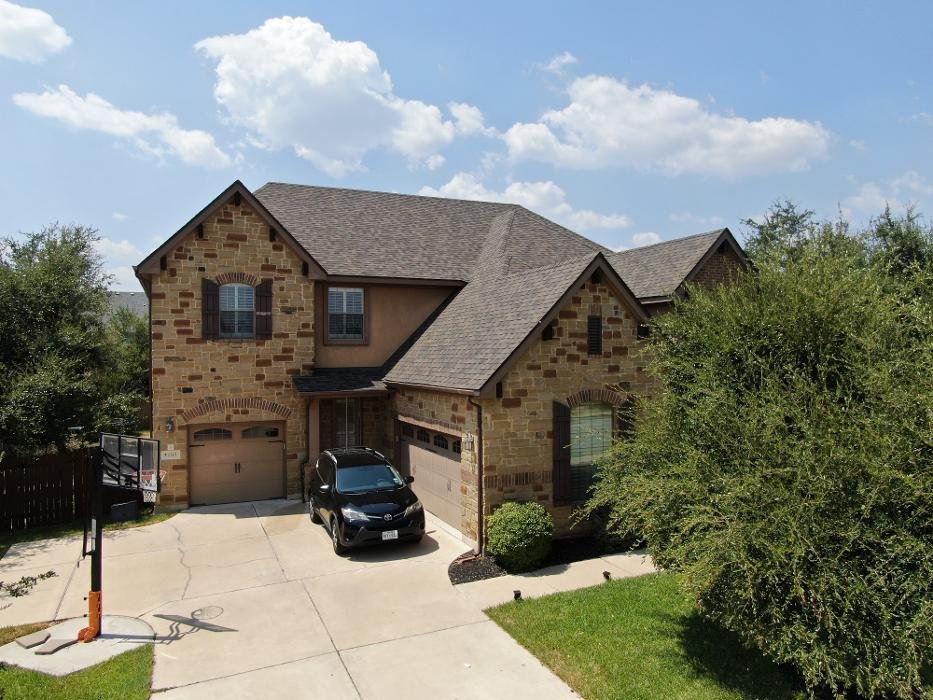 New shingle roof on a two-story stone home, Austin TX