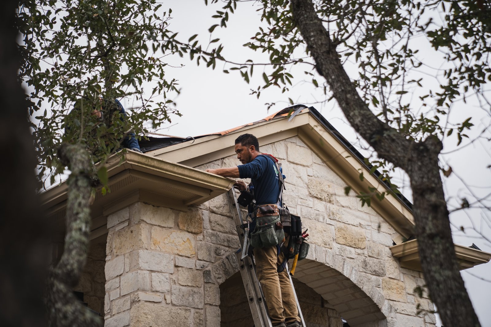 Hermes Roofing crew member working at the gutter line on a Driftwood, Texas home