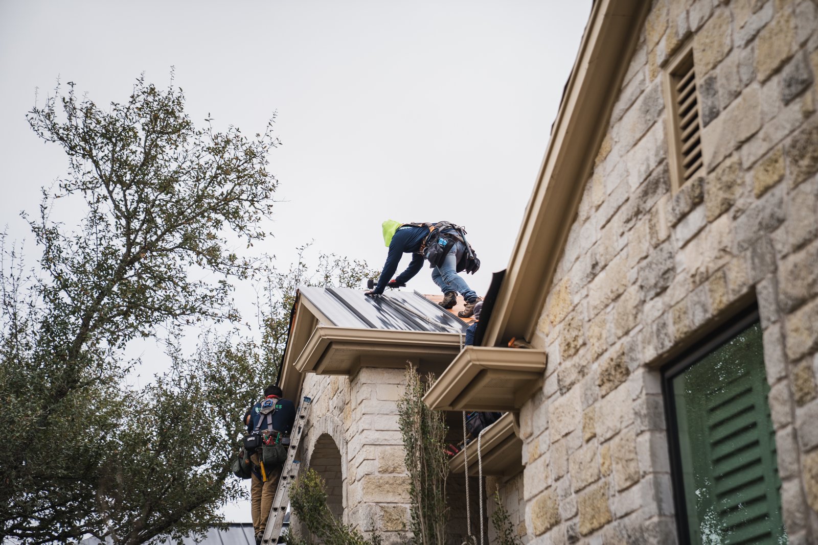 Roofer securing a standing seam panel over the entry